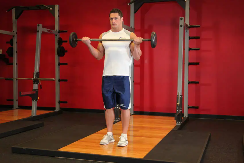 Wide-Grip Standing Barbell Curl — posisi akhir